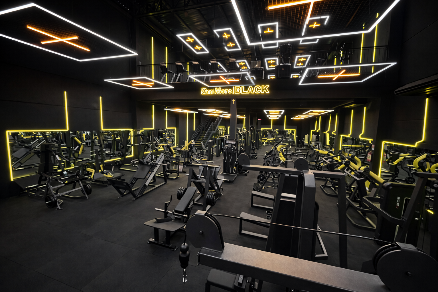 Interior da academia One More Black com iluminação amarela